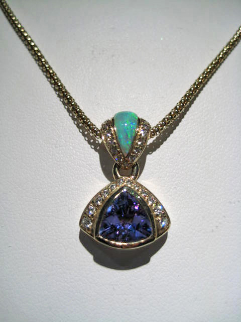 14K Gold Pendant with Opal, 1.64c Tanzanite, and .31c Diamond Artist: Kabana Stavros Catalog: 895-94-9 #18937 Price: $7,500.00 REDUCED: $3,900.00 CHAIN SOLD SEPARATE PRICE: $550.00 REDUCED: $275.00